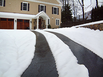 A driveway heating system with heated tire tracks.