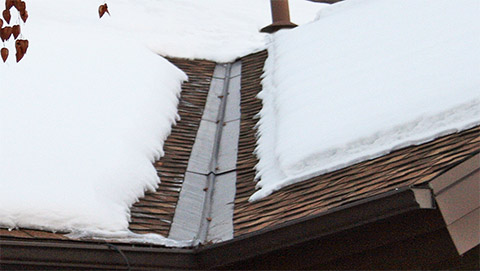 A low-voltage roof de-icing system installed to heat a roof valley and eave. Heated roof valley and eave.